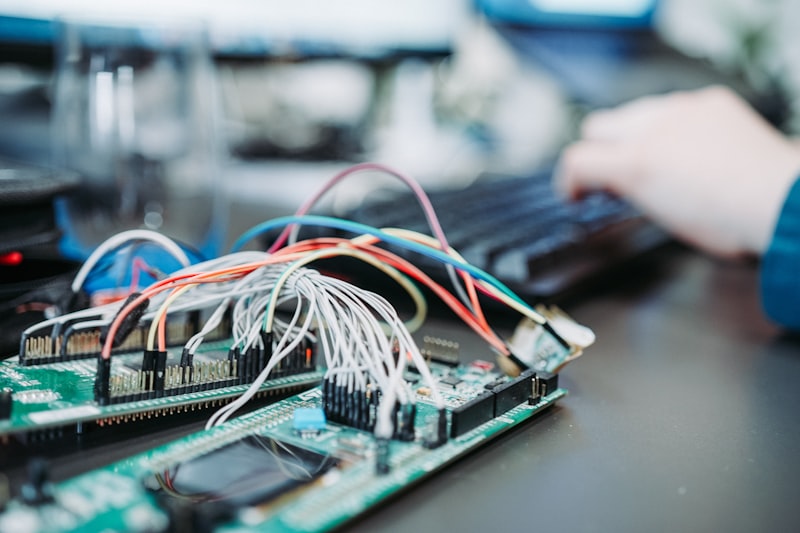 Neatly laid out electronic boards, microcontrollers, and sensory modules on white surface